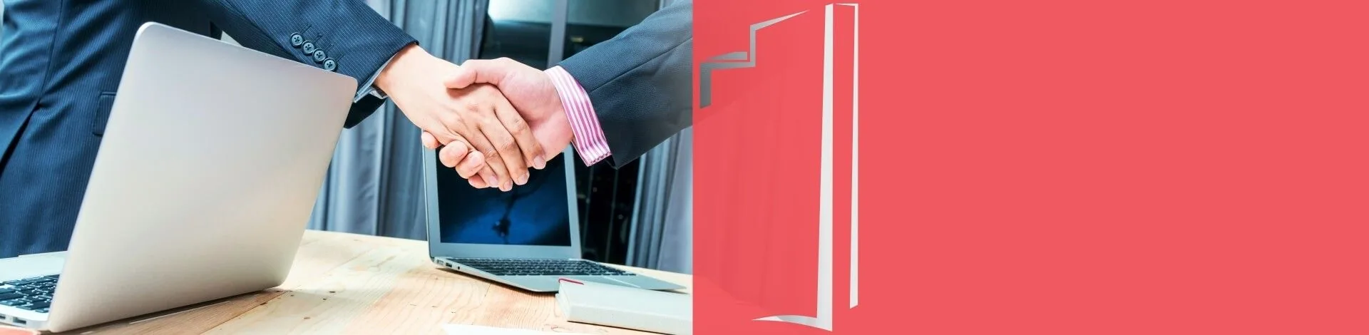Aperto de mãos sobre a mesa com notebooks